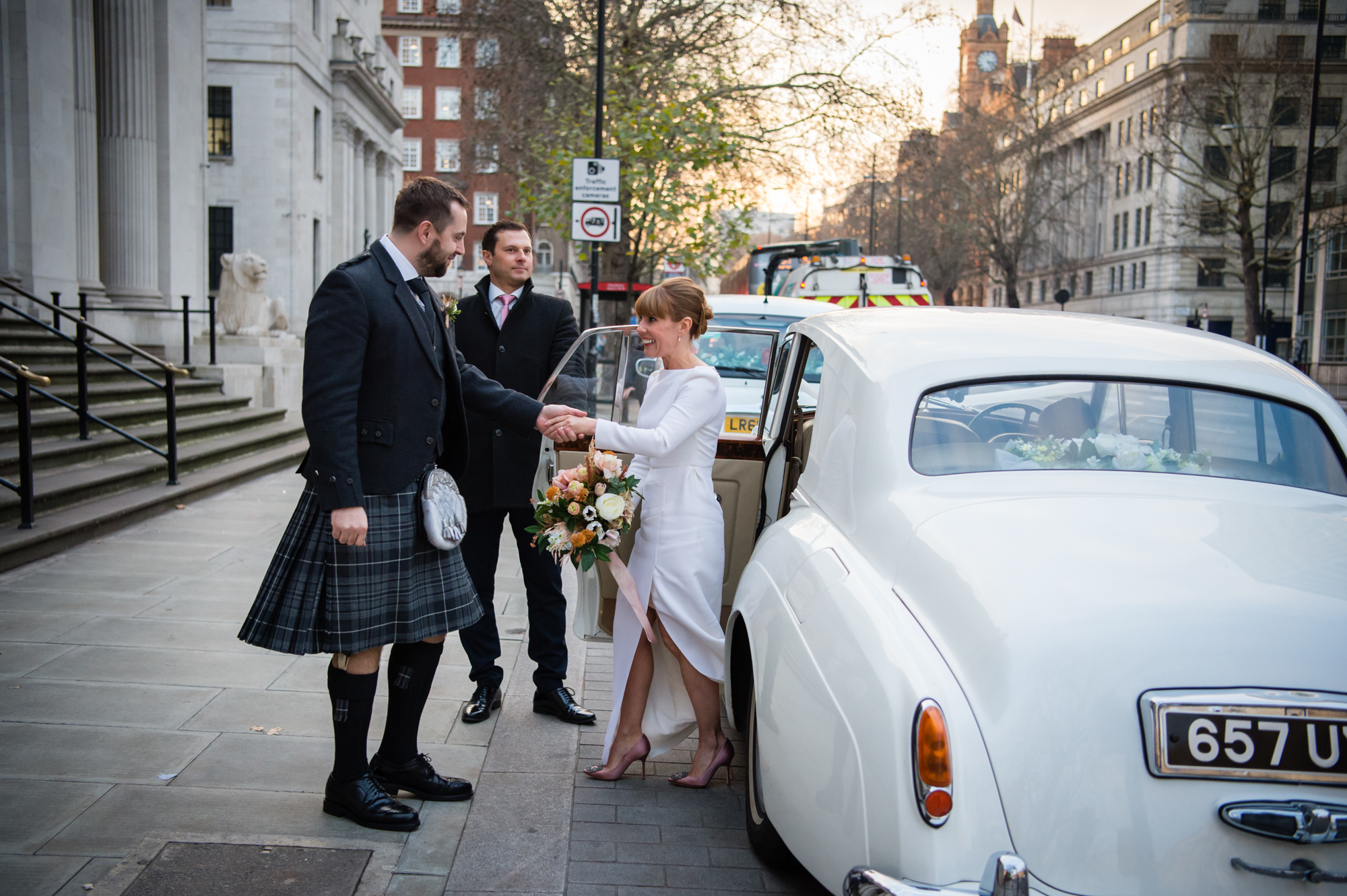 bride arriving in wedding car at marylebone town hall london to get married and celebrate their winter wedding